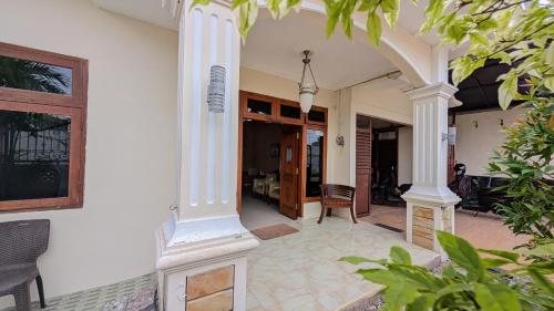 a porch with white columns on a house at Surabaya Homey Dharmahusada Syariah in Surabaya