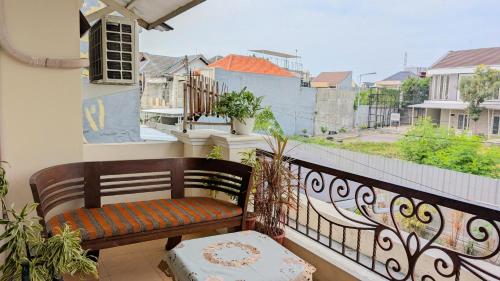 a bench sitting on a balcony with a view at Surabaya Homey Dharmahusada Syariah in Surabaya