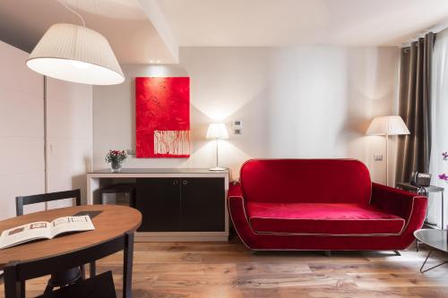 a living room with a red chair and a table at Il Decameron Luxury Design Hotel in Odesa