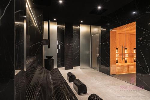 a lobby with black walls and black furniture and chairs at Your Holidays Infinity Sunset Viev A528 in Międzyzdroje