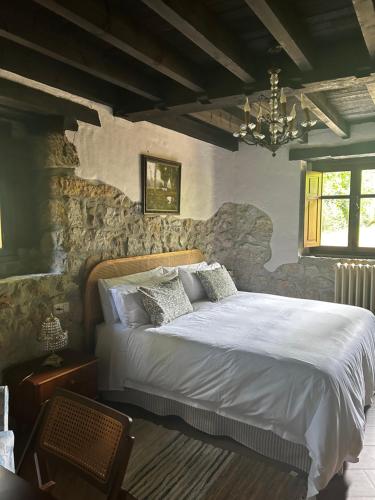 リャネスにあるHotel Boutique Santuario Kunturi - Adults Onlyの石の壁に大きなベッドが置かれた寝室