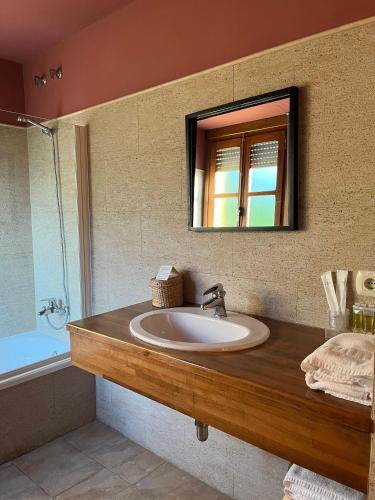 Un baño con lavabo, espejo y bañera. en Novella Hotel de Muntanya, en Benasal