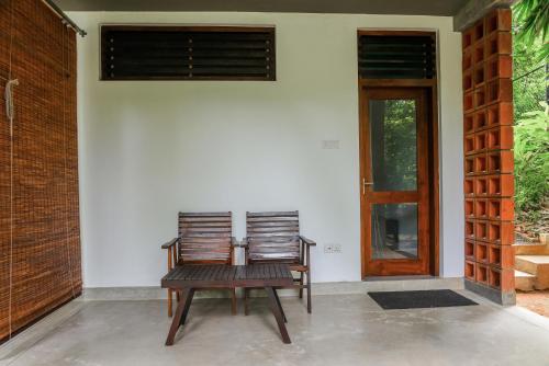 two chairs sitting on the front porch of a house at Paradise Itzu in Kandy