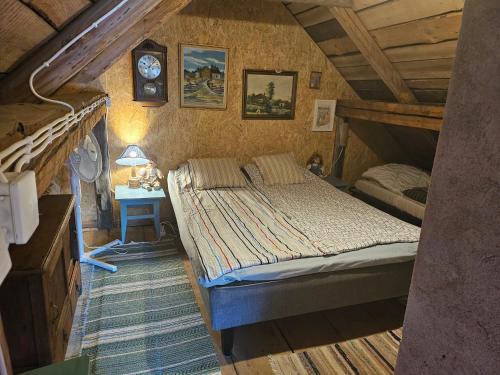 MaakeskiにあるRomantic countryside SAUNA Cottageのベッドルーム1室(ベッド1台、壁掛け時計付)