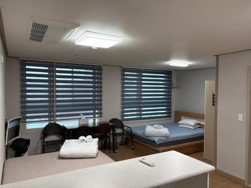 une chambre avec deux lits, une table et des chaises dans l'établissement Marina Residence Hotel, à Busan