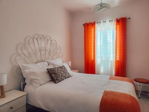 a bedroom with a bed with an orange curtain at Villa Victoria, Tonel, Sagres in Sagres