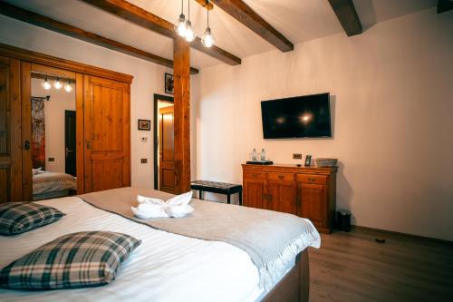 a bedroom with a bed with a tv on the wall at Domeniul Toma in Valea Dobîrlăului