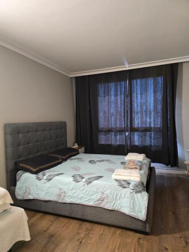 a bedroom with a bed and a large window at Sea Vacation in Haifa