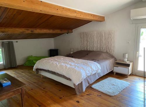 une chambre avec un lit et un parquet dans l'établissement Villa provençale avec piscine, à Fontvieille