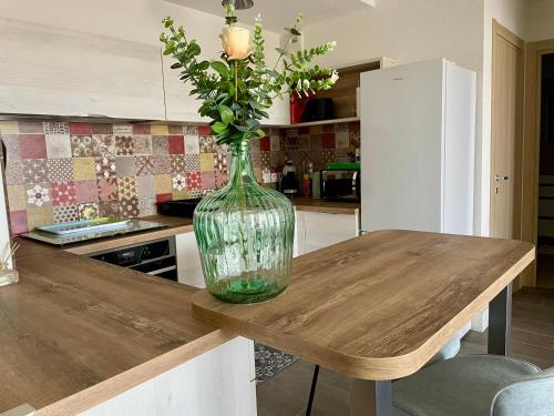 a vase of flowers on a wooden table in a kitchen at T2 moderne et lumineux, clim, terrasse et vue mer in Bastia