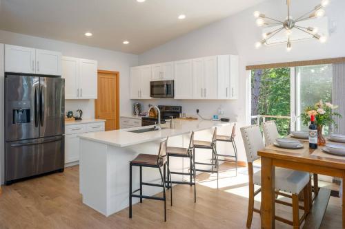 EastsoundにあるStylish, Gourmet Kitchen, Minutes To Moran Parkの白いキャビネット付きのキッチン、バースツール付きのキッチンアイランド