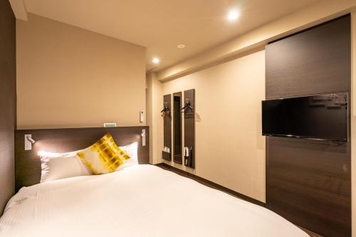 a bedroom with a large bed and a flat screen tv at Red Roof Inn Kamata / Haneda Tokyo in Tokyo