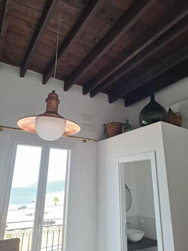 a ceiling light in a room with a window at PHI-Lampara in Santa Flavia