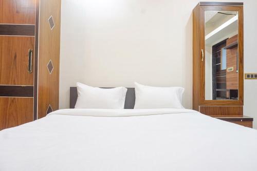 a bedroom with a large white bed and a mirror at FabHotel Classic Square I in Pune
