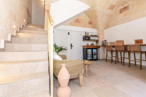 a living room with stairs and a table and chairs at Hotel Ses Sis Roses in Ciutadella