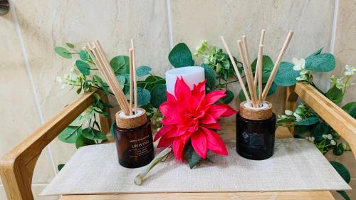 a table with three bottles of essential oils and a red flower at Slavia in Castleknock