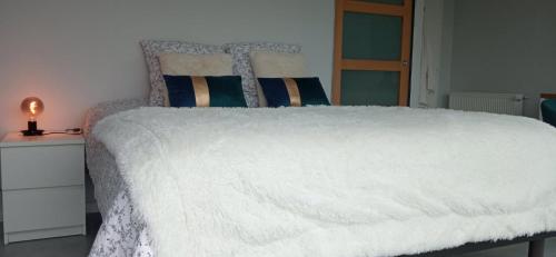 a bedroom with a white bed with a white comforter at Chambre avec terrasse privative et vue mer in Hanvec