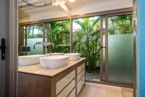 une salle de bain avec deux lavabos et une grande fenêtre dans l'établissement Contemporary Eden - Villa Jeladore, 5BR, Garden & Pool, near Laguna, à Ban Pak Lak