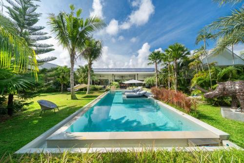 a swimming pool in the middle of a yard with palm trees at Contemporary Eden - Villa Jeladore, 5BR, Garden & Pool, near Laguna in Bang Tao Beach
