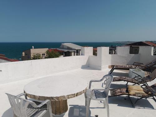a table and chairs on a patio with the ocean at Samaya in Eforie Nord