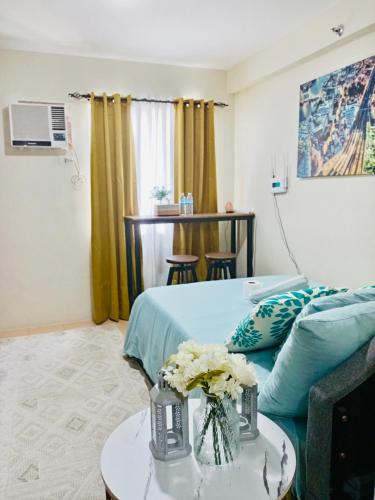 a hotel room with a bed and a table with flowers at Norman Condominium Unit Rental in Dumaguete