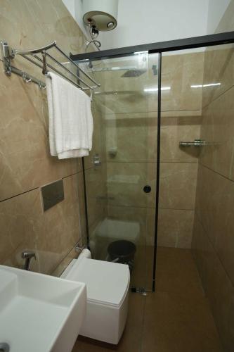 a bathroom with a shower and a toilet and a sink at Ragas - Marari Beach Villa By Perfect Stays in Alleppey