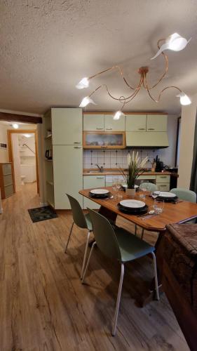 a dining room with a table and chairs and a kitchen at Pré-Art Thermes, Art e Design in Pré-Saint-Didier