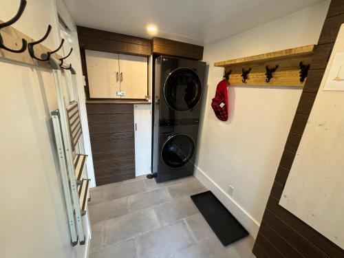a small laundry room with a washer and dryer at Spa - Chalet Sur Les Sentiers du Pic-Bois in Adstock