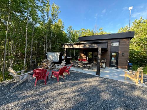 a small cabin with red chairs and a table at Spa - Chalet Sur Les Sentiers du Pic-Bois in Adstock