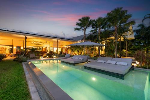 a house with a swimming pool with two couches at Contemporary Eden - Villa Jeladore, 5BR, Garden & Pool, near Laguna in Bang Tao Beach