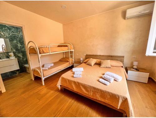 a bedroom with a bed with two bunk beds at Villa Perla Del Mare in Mondragone