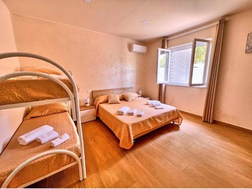 a bedroom with two bunk beds and a window at Villa Perla Del Mare in Mondragone