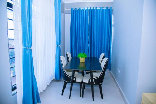 a dining room table with chairs and a potted plant on it at Eastern City Apartments in Dodoma