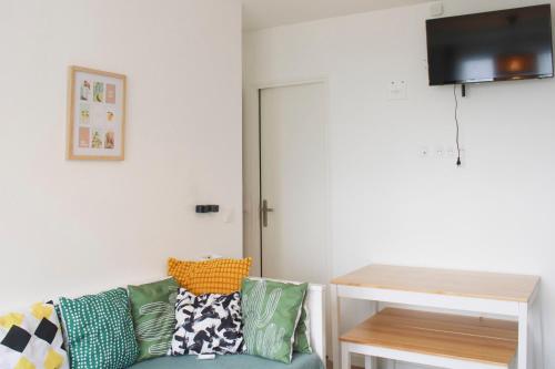 un salon avec un canapé et une table dans l'établissement Charming T3 of 35 m near Paris, à Saint-Denis