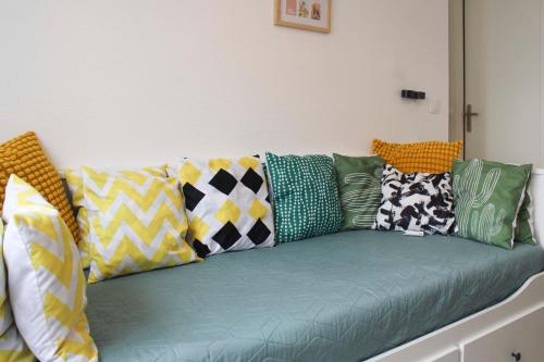 - un canapé vert avec des oreillers colorés dans l'établissement Charming T3 of 35 m near Paris, à Saint-Denis