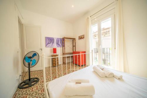 a bedroom with a white bed and a large window at HomeHolidaysRentals Arlene in Calella