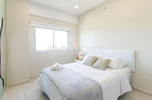 1 dormitorio blanco con 1 cama grande y ventana en Bold Apartment 10 Min From Shopping Mcal Lopez, en Asunción