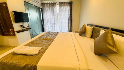 a large bed in a room with a television at HOTEL PANCHAVATI INn in Mahabaleshwar