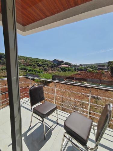 two chairs on a balcony with a view at HOTEL PANCHAVATI INn in Mahabaleshwar