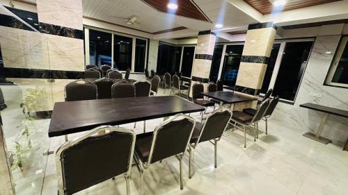 a conference room with tables and chairs and windows at HOTEL PANCHAVATI INn in Mahabaleshwar