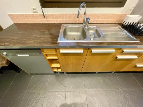 een keuken met een roestvrijstalen wastafel en houten kasten bij Tour Eiffel Francois Gerard in Parijs