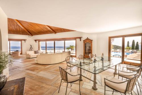 a living room with a glass table and chairs at Villa Artisti Marathon in Marathón