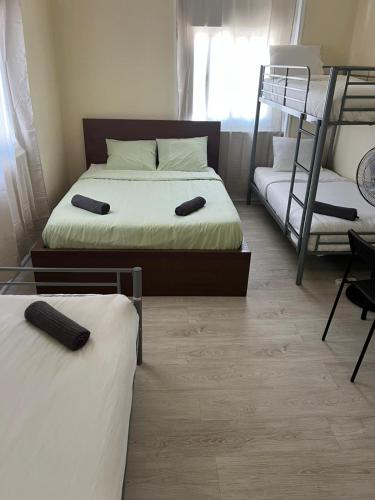 two beds in a room with two bunk beds at Come Inn Costa da Caparica in Costa da Caparica