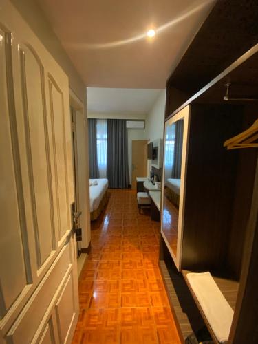 a hotel room with a bedroom with a bed and a door at Soeltan Luxe Hotel Lampung in Bandar Lampung