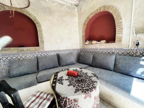 a couch in a room with two arches at Hostel Hotel & Riad in Essaouira