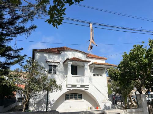 a white building with a red roof at Come Inn Costa da Caparica in Costa da Caparica