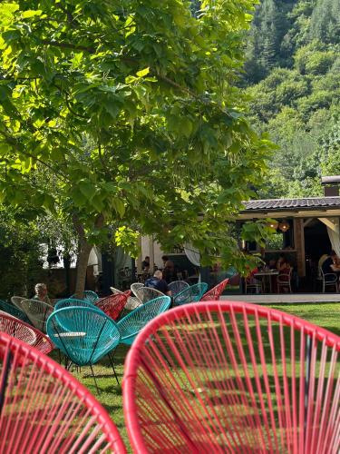 eine Gruppe von Stühlen und Tischen in einem Park in der Unterkunft Vila Sunce Village Resort Konjic in Konjic