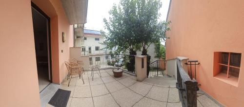 a balcony of a building with chairs and a tree at Ai Gelsi in Lavariano