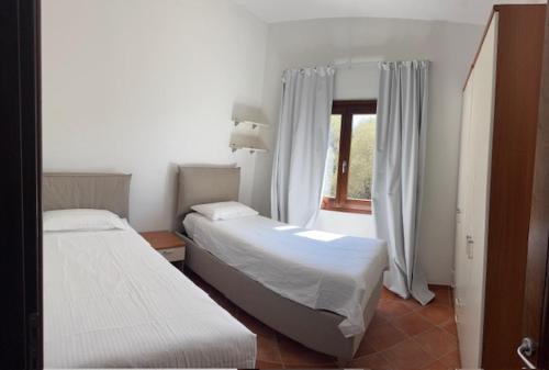 a bedroom with two beds and a window at Le Palme Big Luxury Costa Smeralda in Arzachena