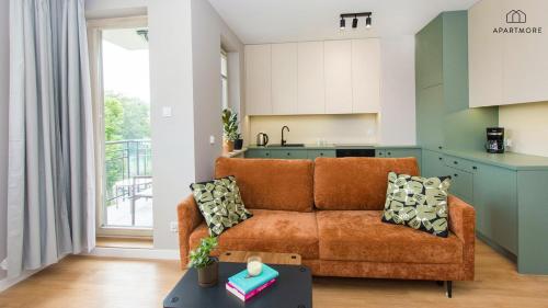 a living room with a couch and a kitchen at Rezydencja Wintera i Lastadia by Apartmore in Gdańsk